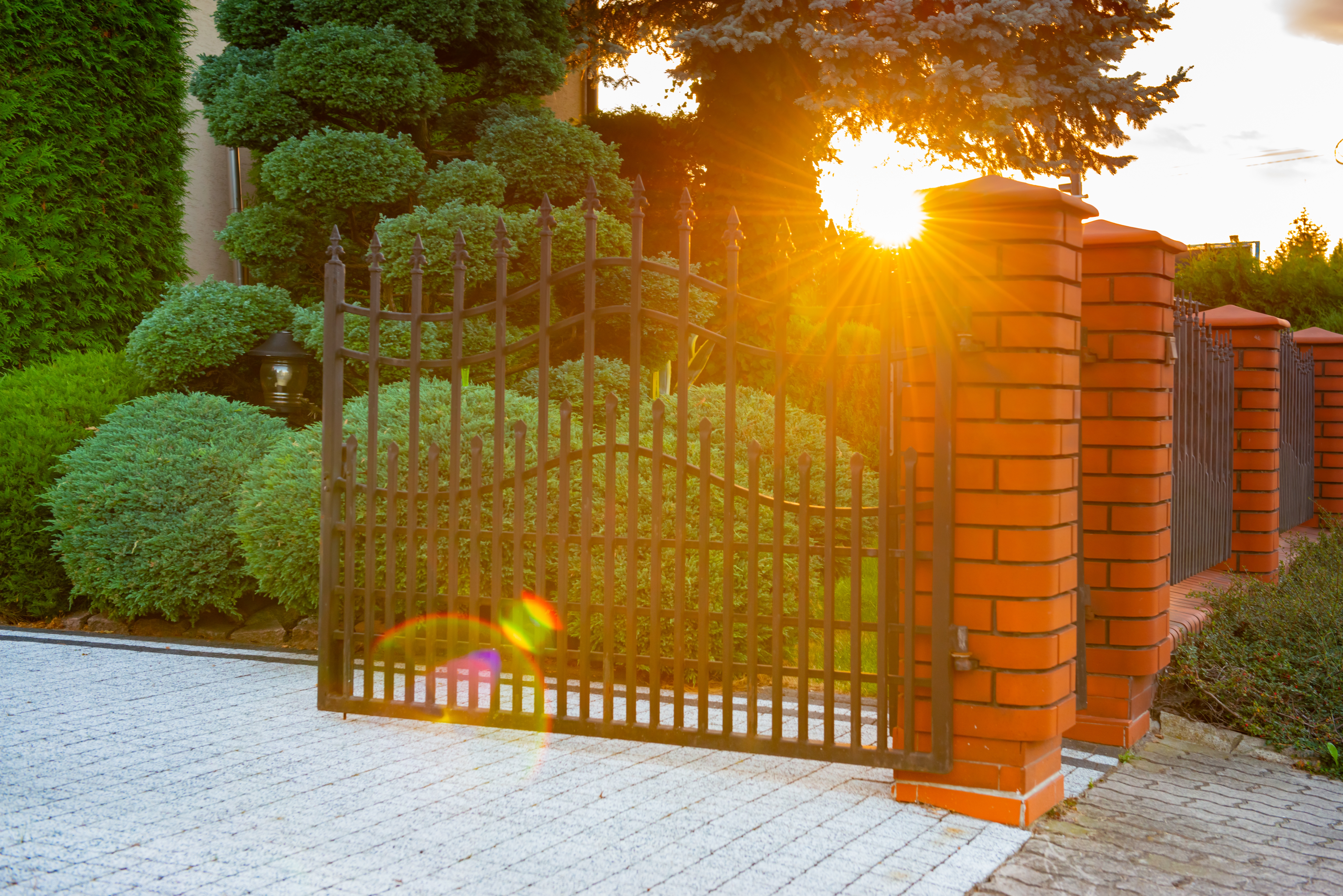 Ornamental iron gate with brick pillars at Fulshear TX property entrance